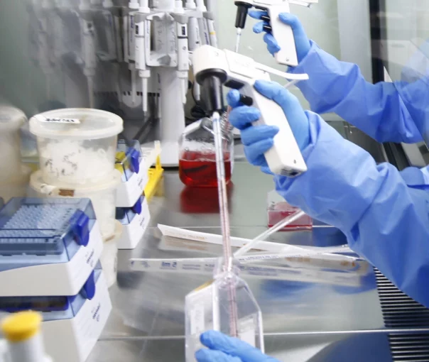 cientists in a laboratory using advanced equipment for research, wearing personal protective equipment and handling precision tools.